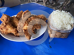 Fried chicken serving on white plate and sticky rice