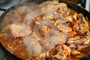 Fried chicken with spices in a pan