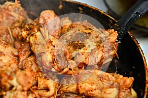 Fried chicken with spices in a pan
