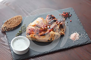 Fried chicken steak with souce and spice on black slate board. Selective focus.