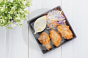 Fried chicken wing and salad on tablecloth on white wood table in kitchen,food menu appetizer