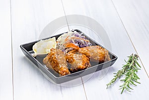 Fried chicken wing and salad on tablecloth on white wood table in kitchen,food menu appetizer