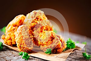 Fried chicken wings and legs on wooden table