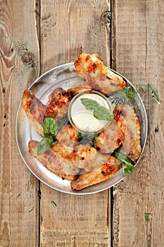 Fried chicken wings with sauce on rustic table