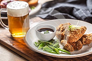 Fried chicken wings with sugar peas herbs and draft beer