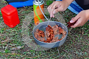 Fried Chinese sausage in a picnic pan with canned gas