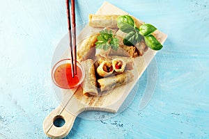 Fried chinese spring rolls with sweet chili sauce on rustic background