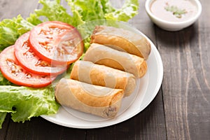 Fried Chinese traditional spring rolls on wooden background.