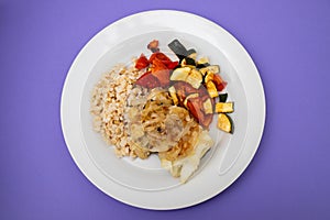 fried cod fish with onion, vegetables, rice and olive oil on plate