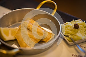 Fried cod in metal pan and mashed potatoes in plate