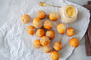 Fried cottage cheese doughnuts with vanilla sauce on a baking pa