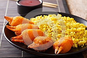 Fried crab claws in breadcrumbs with spicy yellow rice close-up