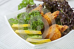 Fried crab claws with cucumber, lemon, lettuce and parsley