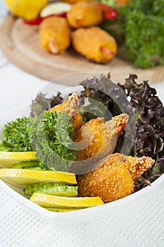 Fried crab claws with cucumber, lemon, lettuce and parsley