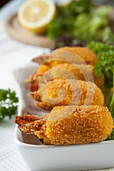 Fried crab claws with cucumber, lemon, lettuce and parsley