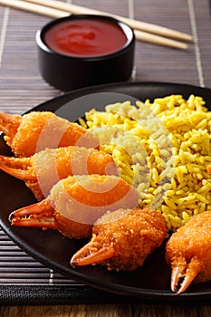 Fried crab claws tempura with rice close-up on a plate. vertical