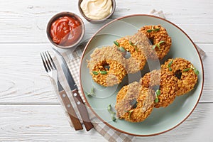 Fried crispy breaded chicken donuts close-up on a plate. Horizontal top view