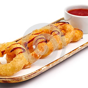 Fried crispy squid rings breaded caramari with red sauce on white backgruond
