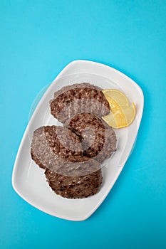 fried cutlet for burger with lemon. In a white plate