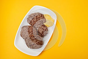 fried cutlet for burger with lemon. In a white plate