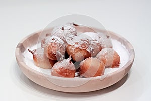 Fried dough balls delicacy of Slovenia called miÅ¡ke in a wooden bowl on a bed of caster sugar