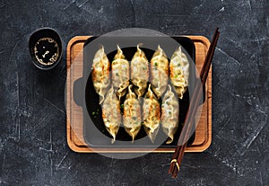 Fried dumplings Gyoza in pan, soy sauce, chopsticks