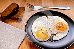 fried egg on black plate on wooden table