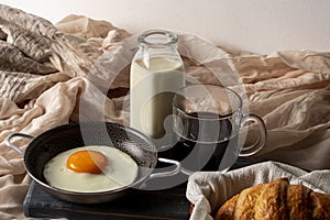 Fried egg with bread and coffee with milk