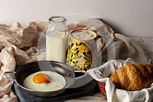 Fried egg with bread and coffee with milk