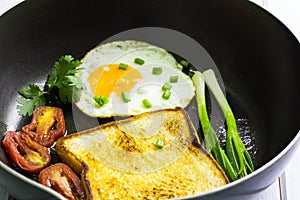 Fried egg and bread in the pan placed on table