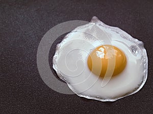 Fried egg. Close up view of the fried egg on a frying pan. Salted and spiced fried egg on cast iron pan