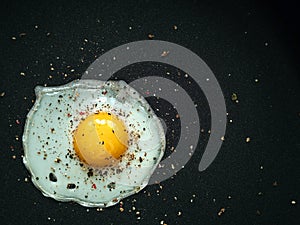 Fried egg. Close up view of the fried egg on a frying pan. Salted and spiced fried egg on cast iron pan