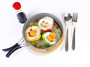 Fried egg on colorful peppers on pan