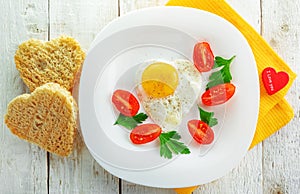 Fried egg and a couple of slices of bread in the shape of a heart