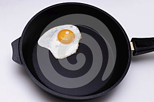 Fried egg in a frying pan. A popular breakfast is scrambled eggs. The photo