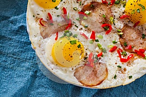 Fried egg with ham sausage and pepper in a white plate