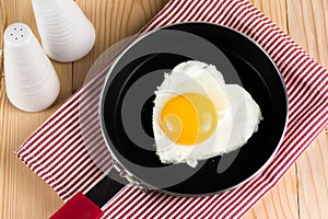 Fried egg in heart shape on pan