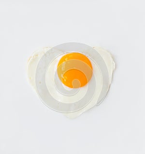 Fried egg in heart shape on a white plate love