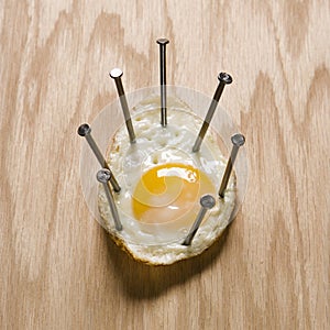 Fried egg nailed to wood.