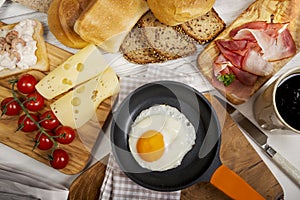 Fried egg in pan, cheese, ham, bread and buns