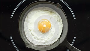 Fried egg on a pig-iron frying pan preparation process time lapse