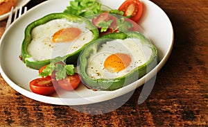 Fried egg in the ring of the bell peppers with herbs