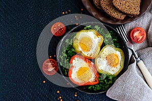 Fried egg in the ring of the bell peppers with herbs and brown bread - light diet breakfast.