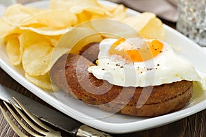 Fried egg with sausage and chips on plate