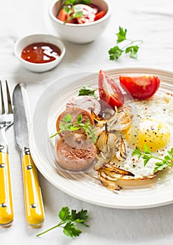 Fried egg, sausage, tomatoes - tasty Breakfast or snack, on the bright plate