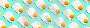 Fried egg or scrambled eggs pattern on blue background. Creative food concept. Top view. Conceptual trend. Banner. Keto diet.