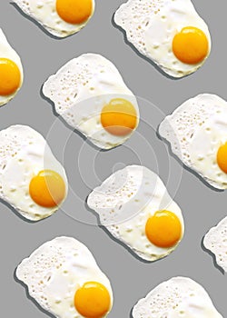 Fried egg or scrambled eggs pattern on grey background. Creative food concept. Top view. Conceptual trend. Banner. Keto diet.