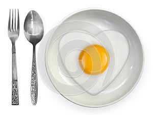 fried egg side up a plate with spoon and fork on a white background