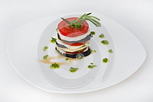 Fried eggplant in circles alternating with mozzarella, tomatoes