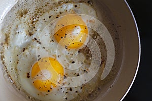 Fried eggs from 2 eggs in a frying pan. Hot Sunny dish